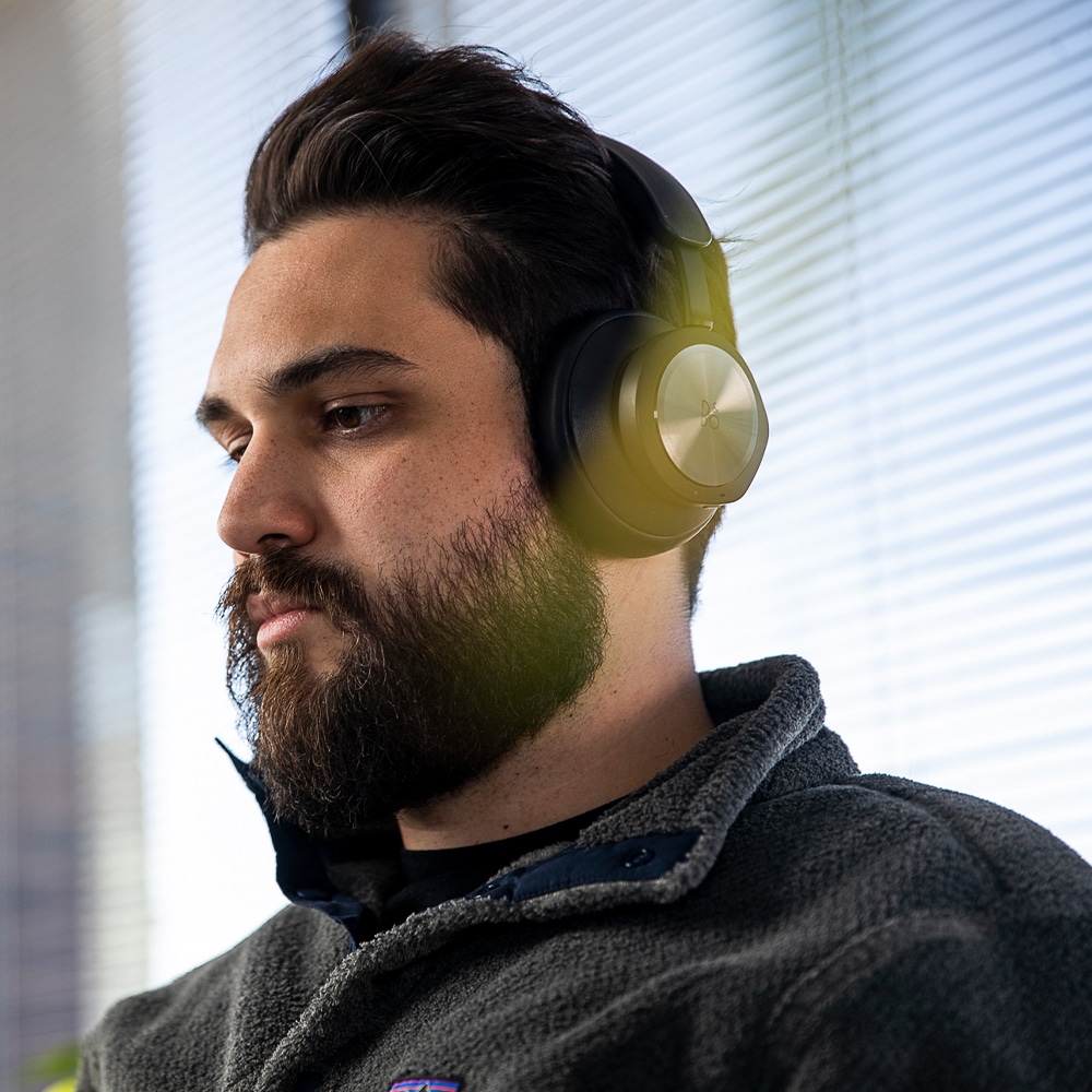A man listening to a podcast through headphones in an office